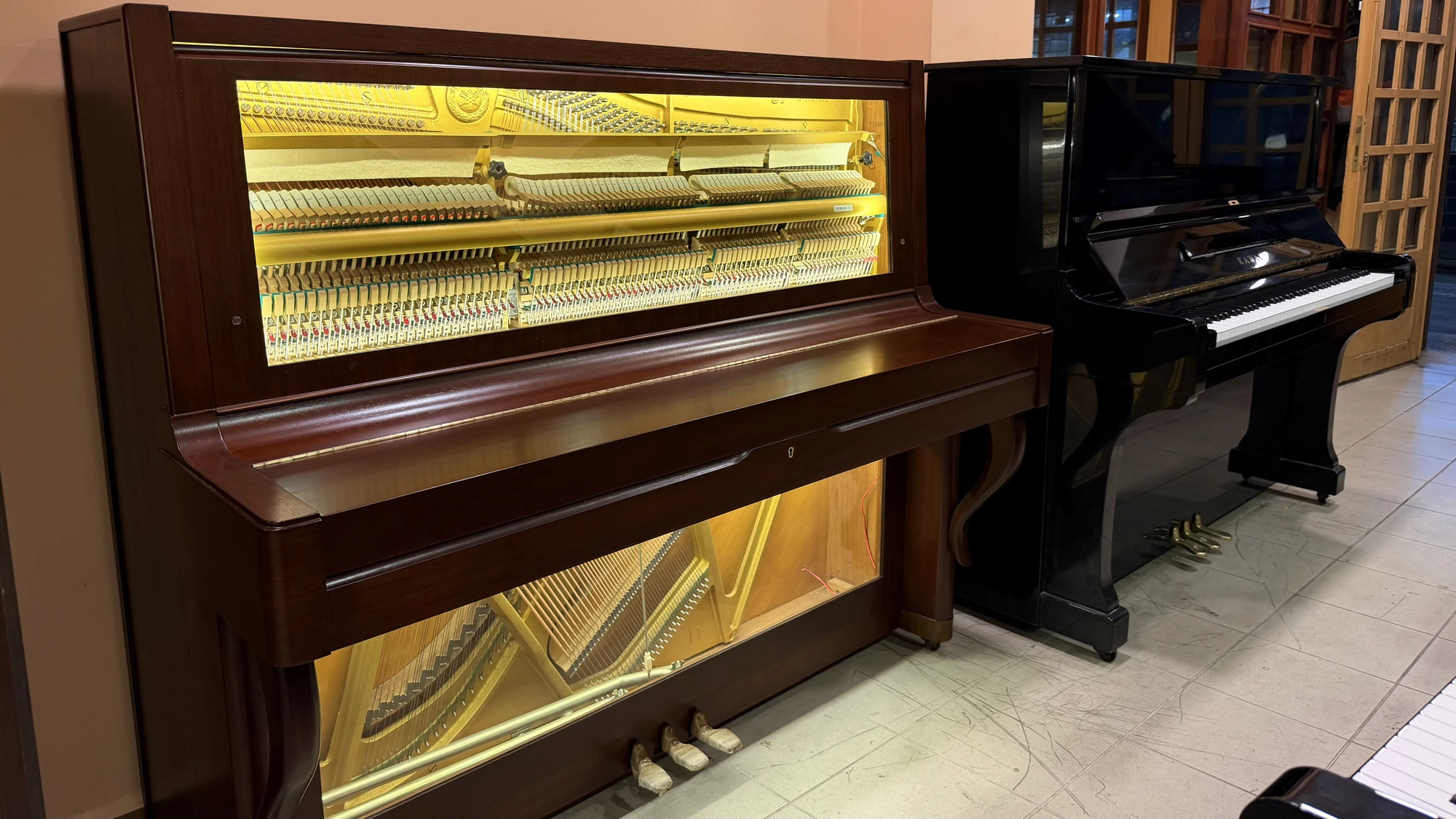 An upright piano with its front removed, the strings and action in view, Basbous & Sons atelier