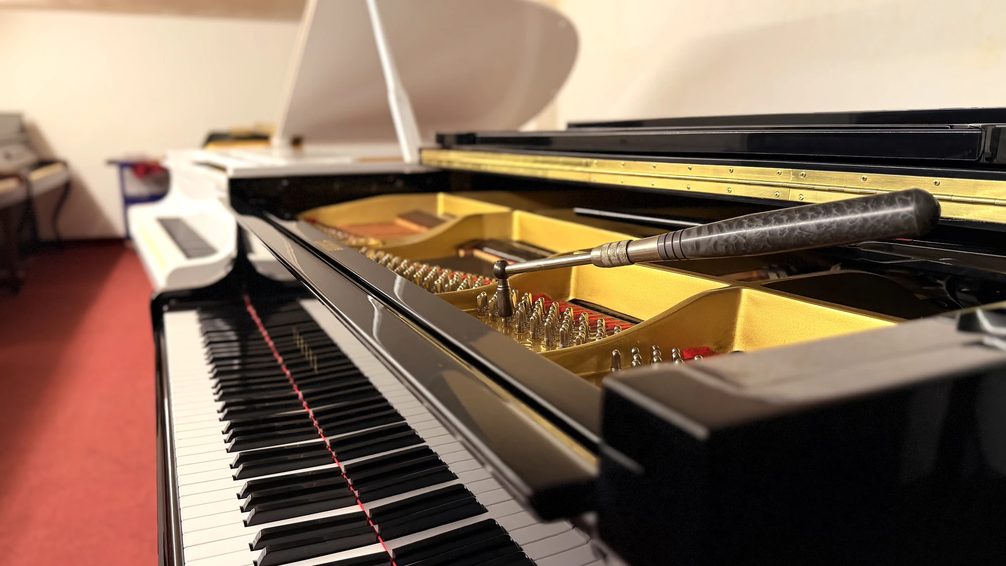 A tuning hammer on the pins of a Yamaha grand piano, Basbous & Sons